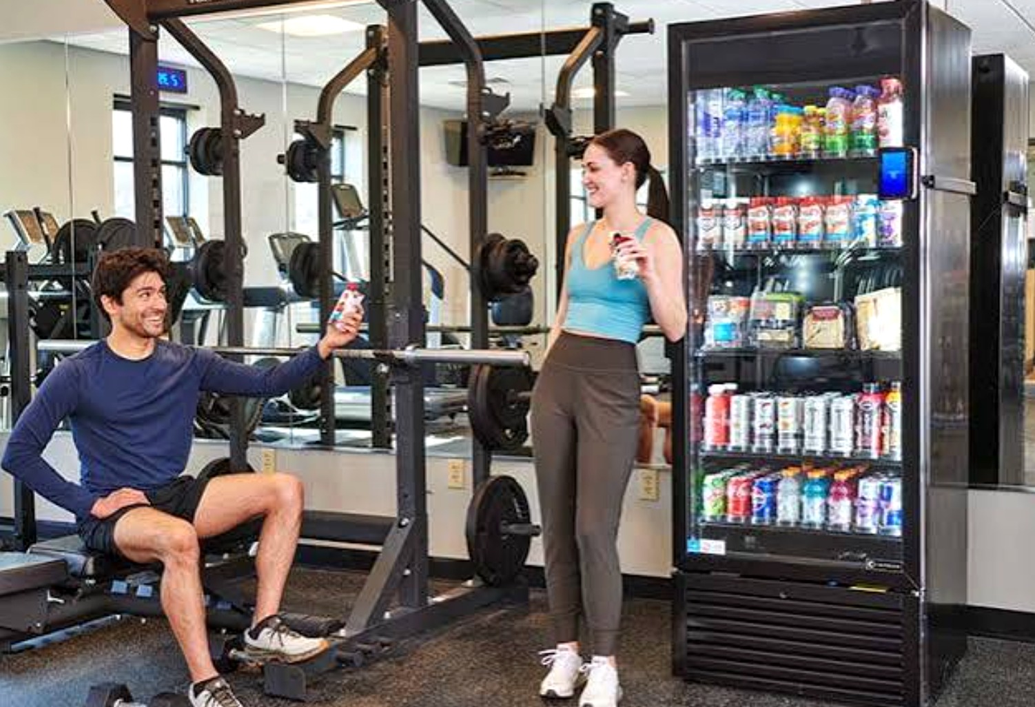 Smart beverage cooler stocked with cold drinks in a bright fitness center